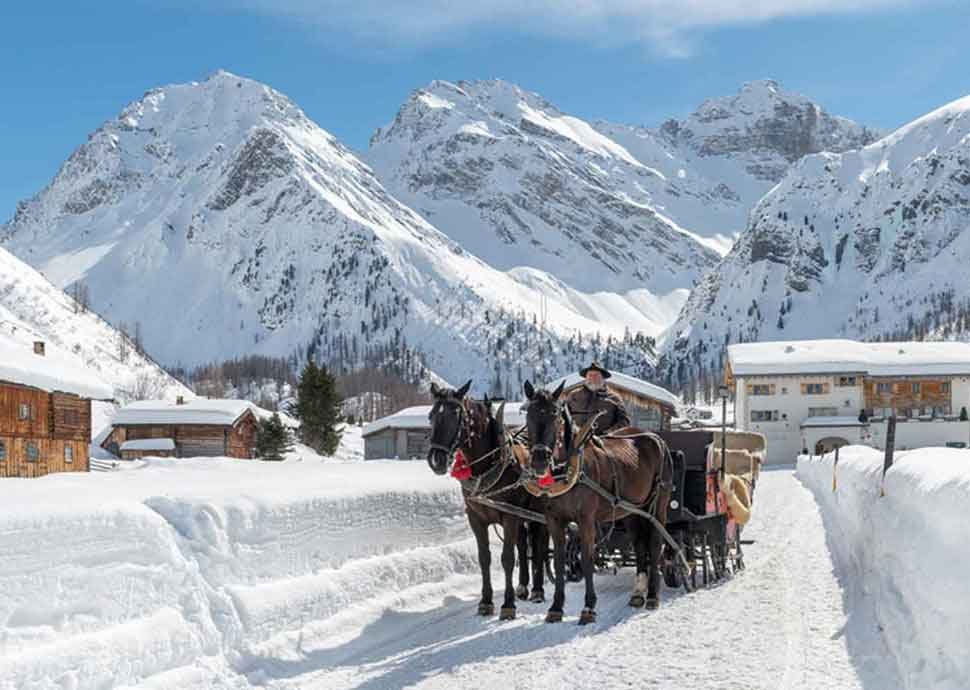 Pferde-Kutschenfahrt in den verschneiten Bündner Bergen.
