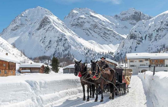 Pferde-Kutschenfahrt in den verschneiten Bündner Bergen.